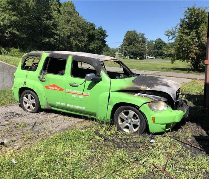 green service vehicle, burned from the inside with the SERVPRO logos on the exterior